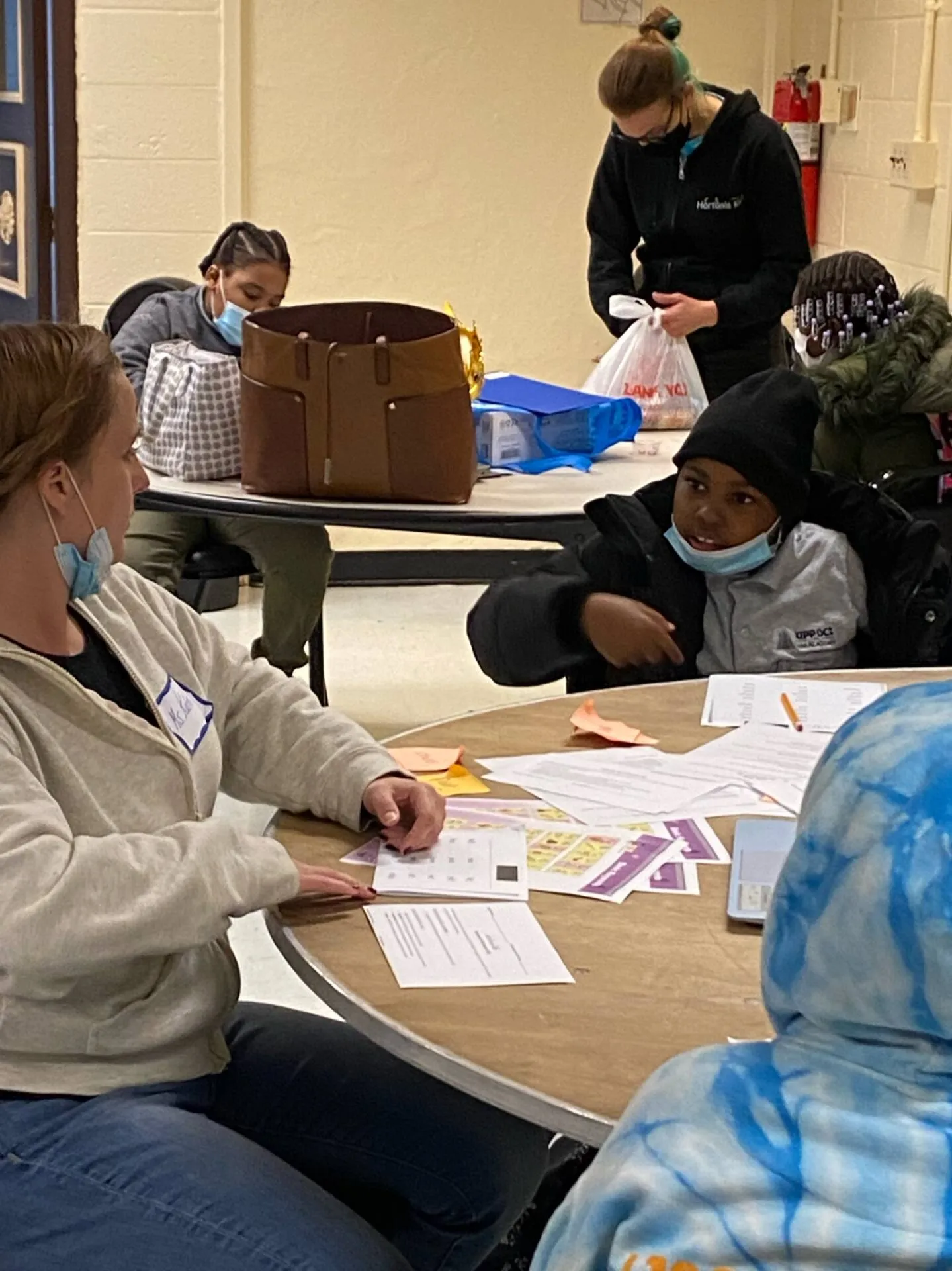 Groups of students receive tutoring at various tables