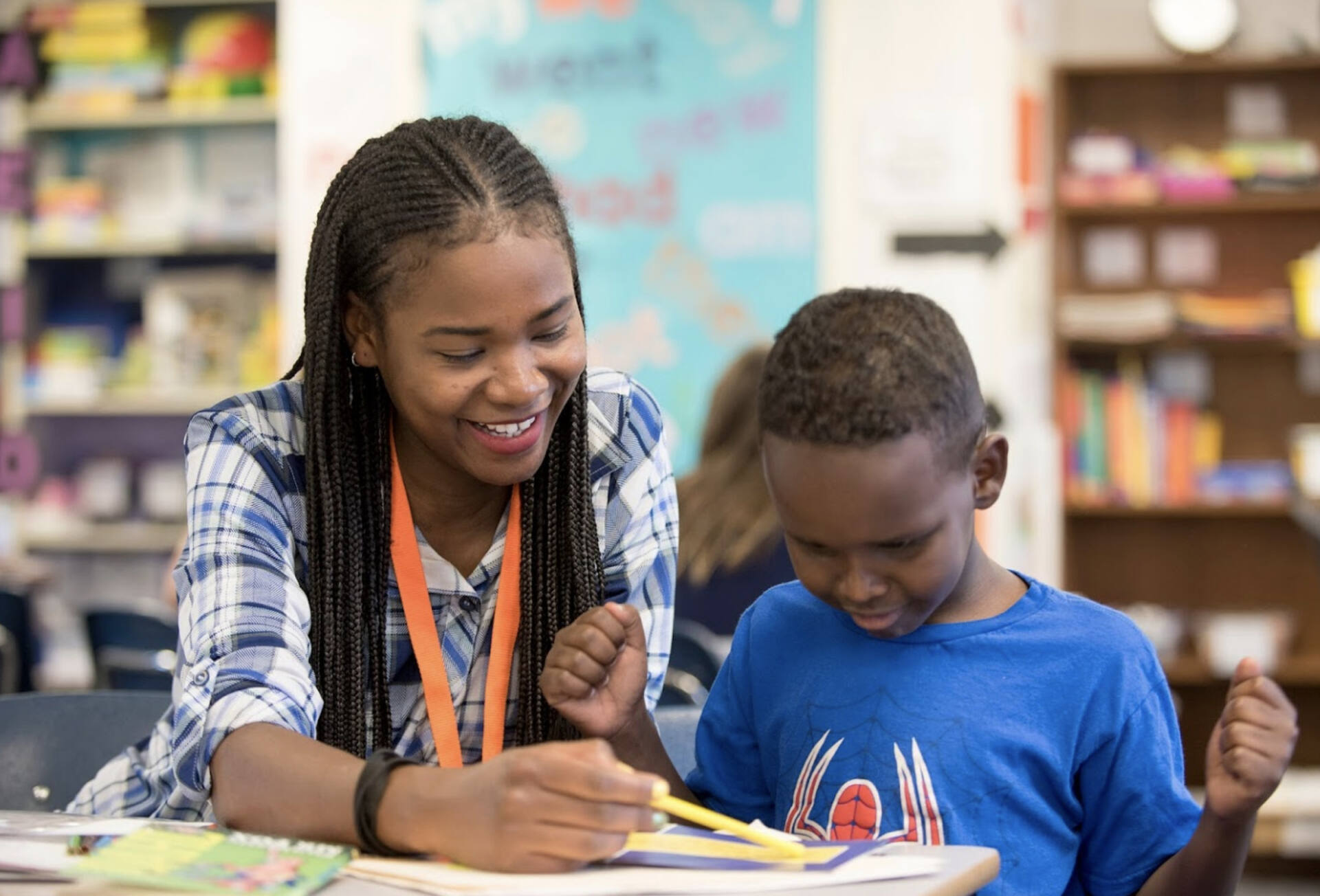 Tutor points our word on paper to a student