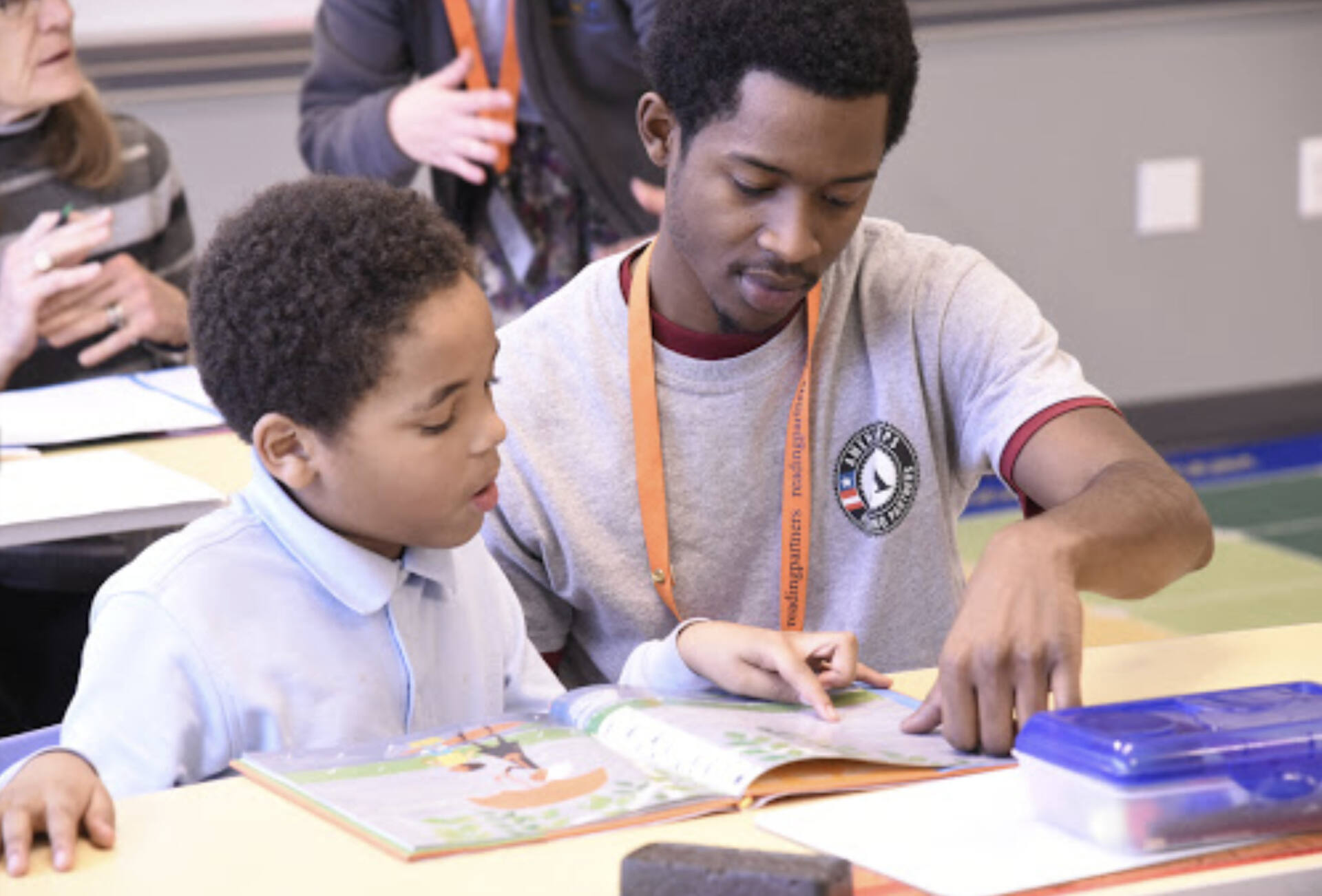 Tutor helps student read book