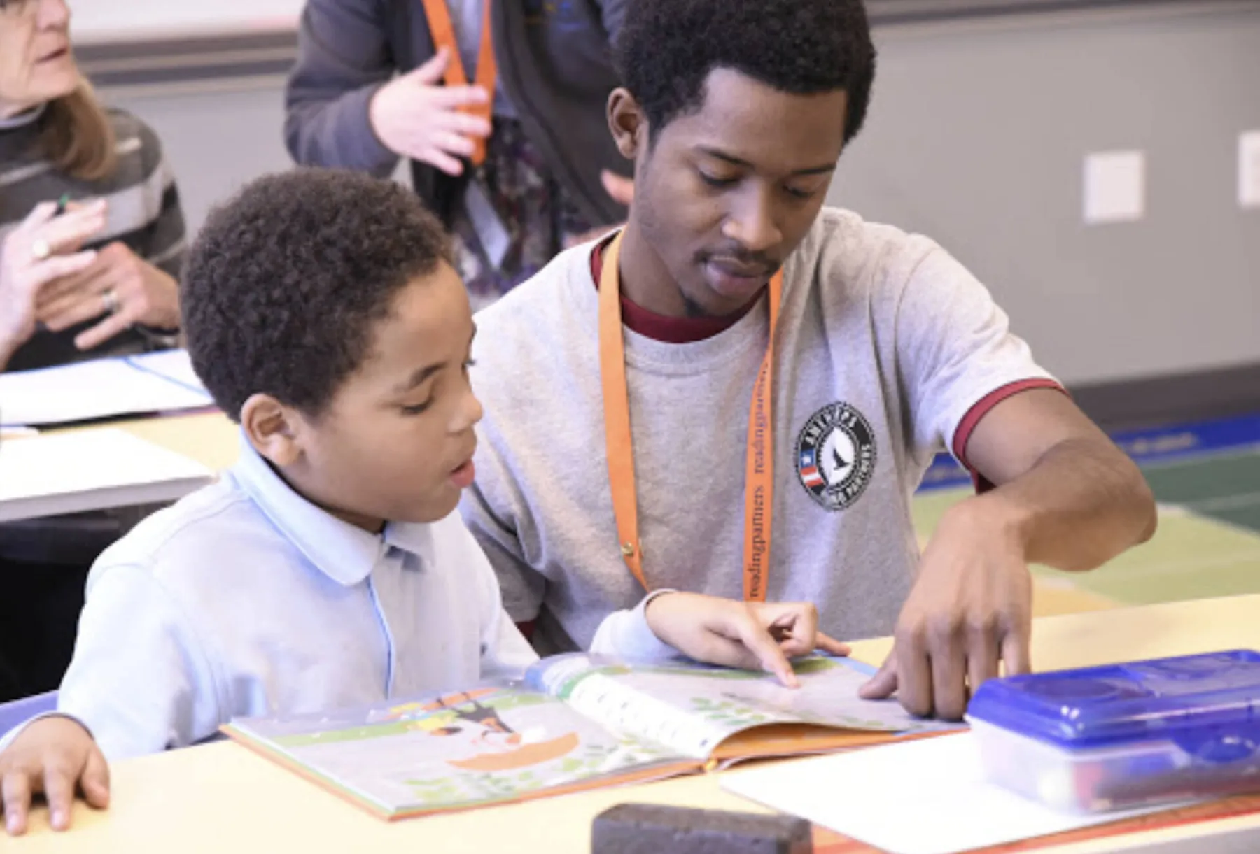 Tutor helps student read book