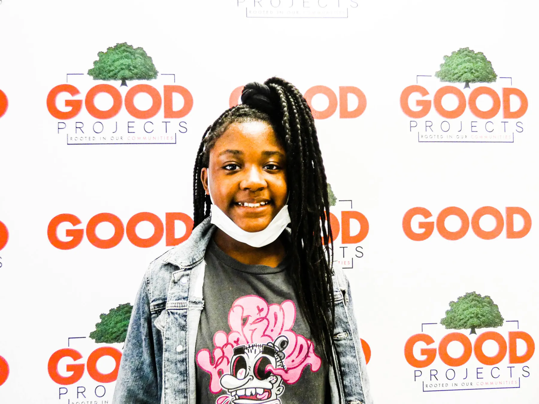 Smiling girl standing in front of a repeating GOODProjects backdrop