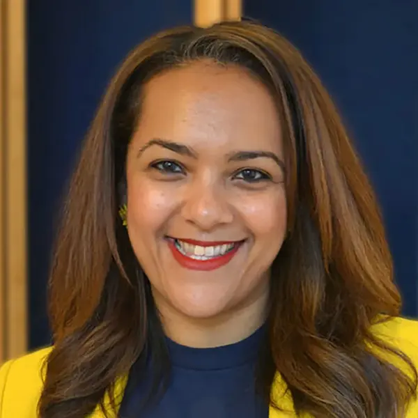 Smiling woman with shoulder-length hair wearing a yellow top