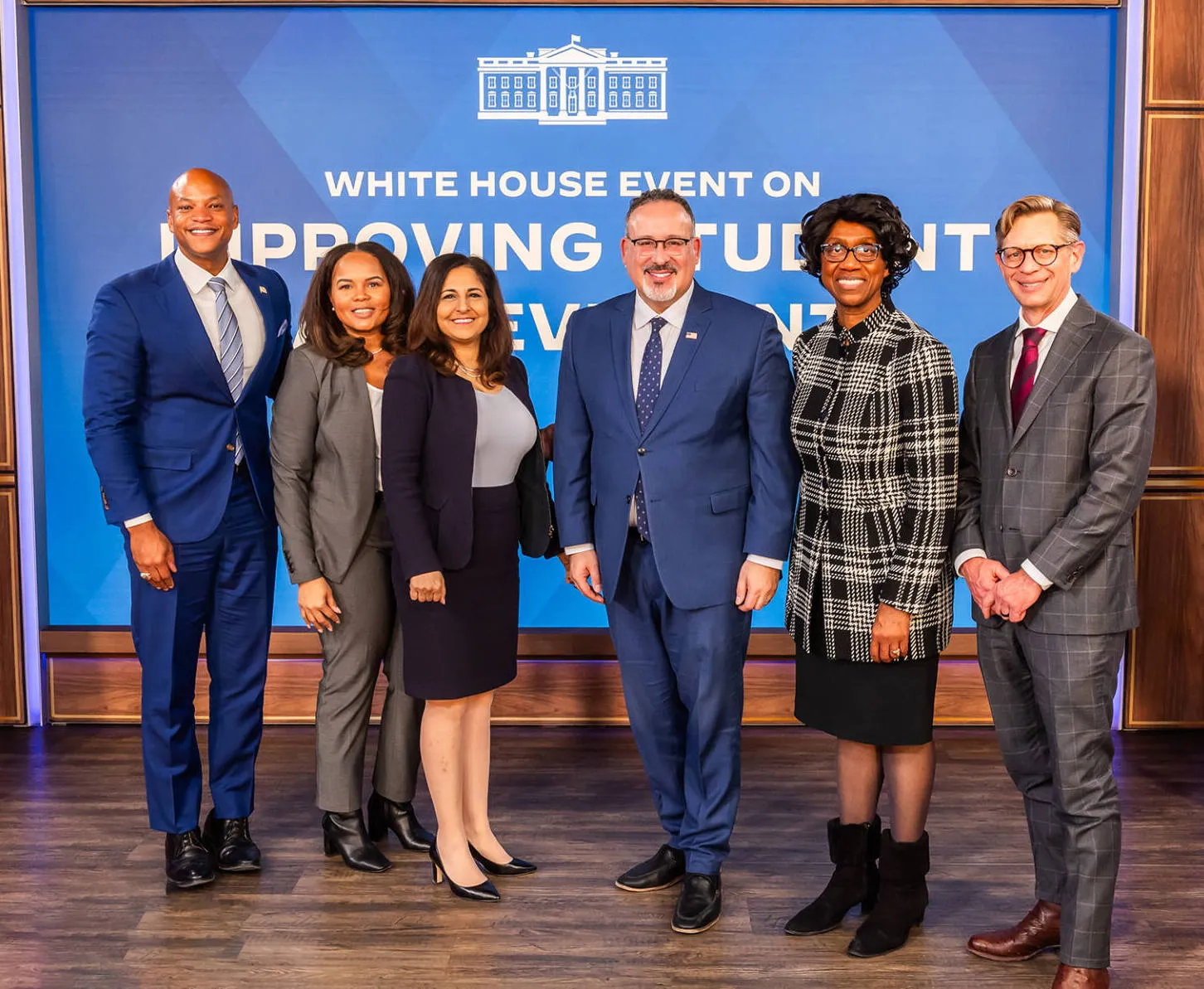Seven adults posing together at a White House event