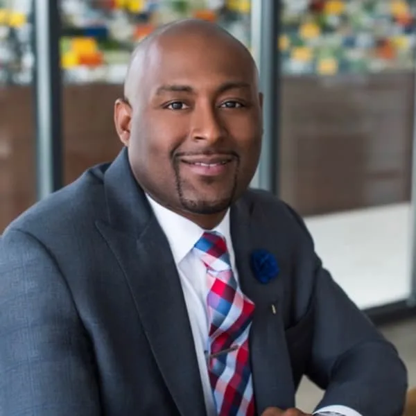 Portrait of a man in a suit with a striped red and blue tie