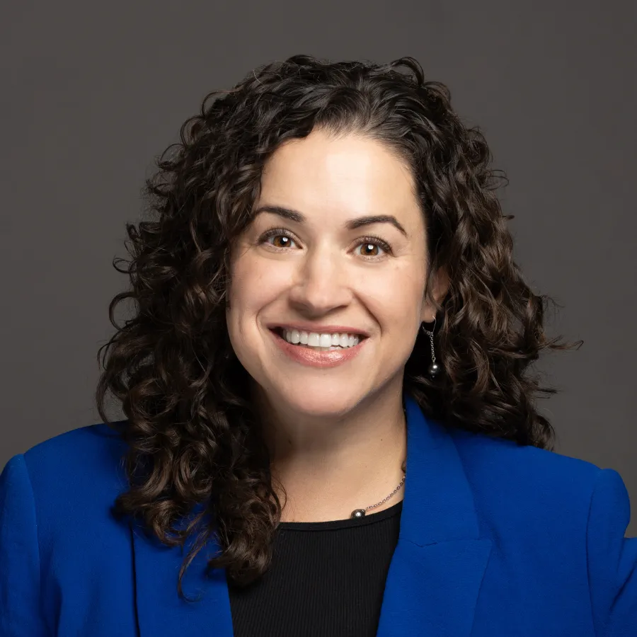 Woman with curly hair wearing a bright blue blazer