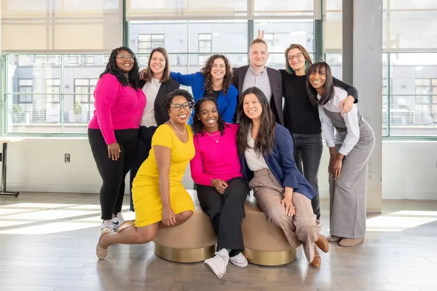 Group of nine adults posing together indoors