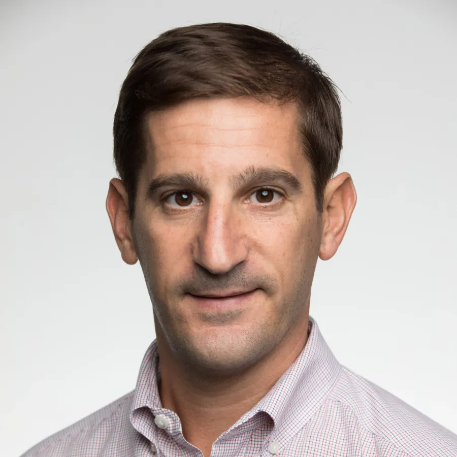 Man in a light shirt against a plain gray background