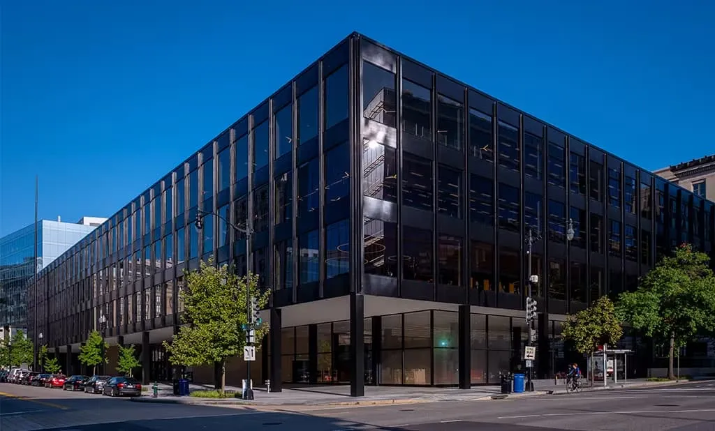 Modern glass-and-steel library building under a blue sky