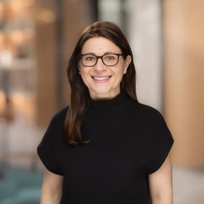 Smiling woman with glasses wearing a black top